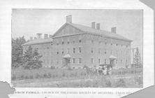 SA0425 - Photo of a large building, also showing a horse and buggy and people.